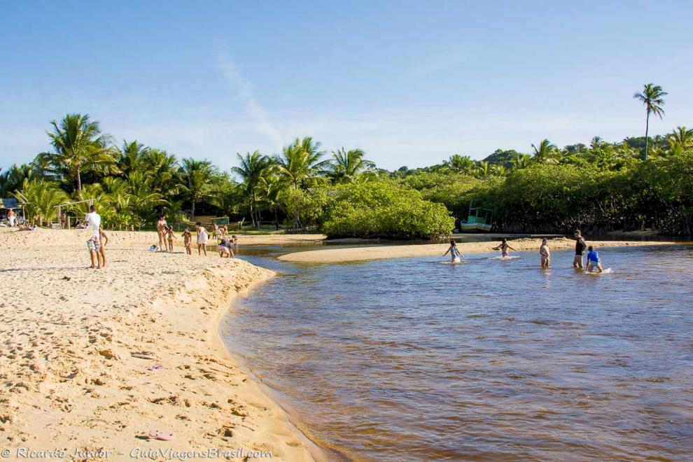 Imagem de crianças nas águas da piscina natural.